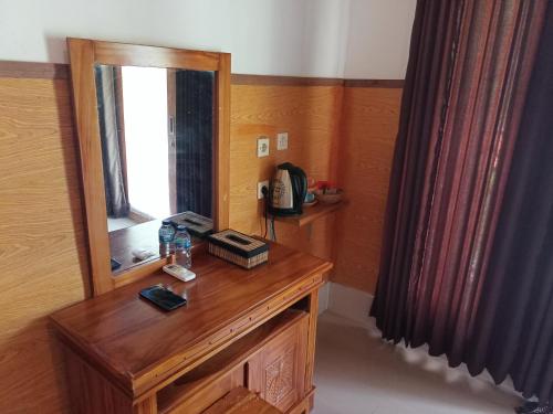 um quarto com uma mesa de madeira e um espelho em Grealeen Cottages em Nusa Penida