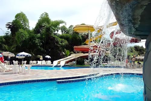 a water slide in a pool at a resort at ÁGUAS TERMAIS NATURAIS nas PISCINAS com ÁGUAS QUENTES 24 HORAS acesso GRÁTIS aos PARQUES AQUÁTICOS dos RESORTS GOLDEN DOLPHIN GRAND HOTEL do SUPREME e do EXPRESS os melhores HOTÉIS RESORTS com PARQUE AQUÁTICO em CALDAS NOVAS Garanta JÁ PROMOÇÃO QUALIDADE in Caldas Novas