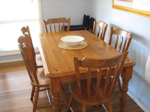 a wooden table with chairs and a bowl on it at Horace Street 8 in Shoal Bay