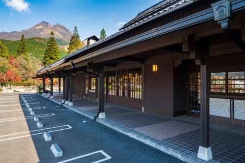 um edifício com estacionamento com montanhas ao fundo em Baien em Yufu