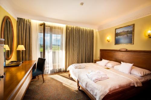 a hotel room with a large bed and a desk at Hotel International in Veľká Lomnica