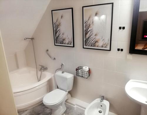 a white bathroom with a toilet and a sink at Great Polonia Jelenia Góra City Center in Jelenia Góra