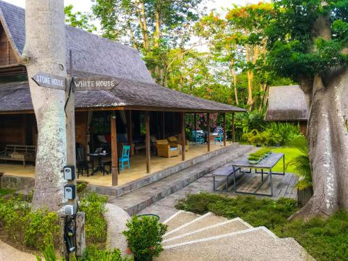 a white house with a sign on a tree at Chanteak Bali in Jimbaran