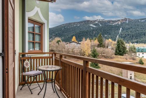 einen Balkon mit einem Tisch und Stühlen sowie Aussicht in der Unterkunft Dimora La Val in Andalo