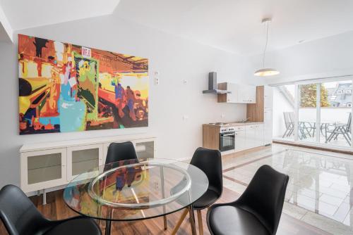 une salle à manger avec une table et des chaises en verre dans l'établissement Hotel Aurora, à Wiesbaden