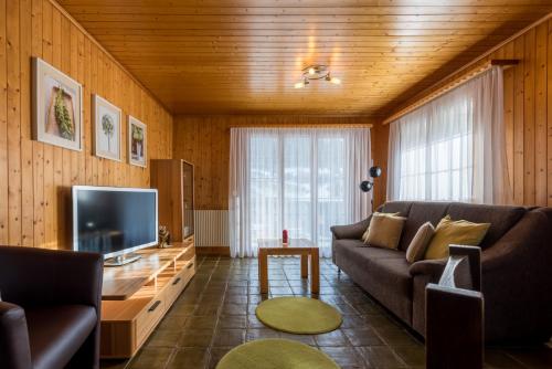 a living room with a couch and a television at Chalet Sunnegga in Fiesch