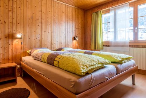 a bedroom with a bed in a wooden wall at Chalet Sunnegga in Fiesch