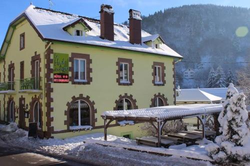 バッス・シュル・ル・リュプトにあるHotel Restaurant Du Haut Du Rocの雪の大きな黄色の建物