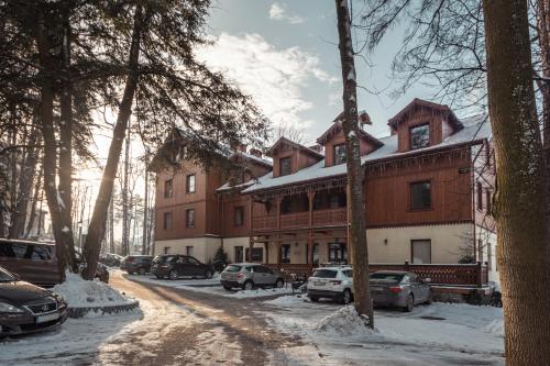 ein großes Gebäude mit davor geparkt in der Unterkunft Hotel Batory in Szczawnica