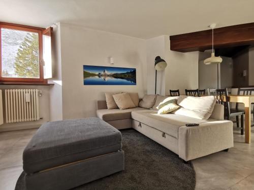 a living room with a couch and a table at Aura Apartment - Ski In & Ski Out - Cerviniaholidays-com in Breuil-Cervinia