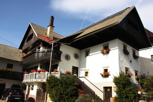 ein weißes Haus mit Blumen auf den Balkonen in der Unterkunft Garden Apartments Maria in Bled