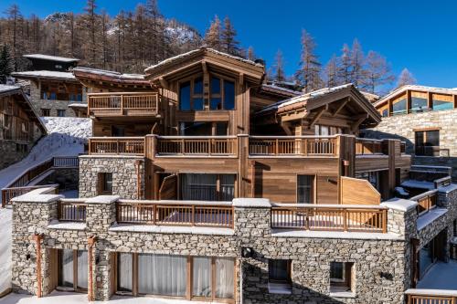 een grote boomhut met een terras in de sneeuw bij Alaska Lodge by Alpine Resorts in Val dʼIsère