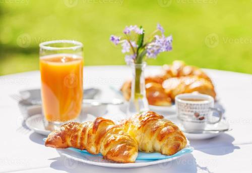 een tafel met gebakjes en een glas sinaasappelsap bij Wellness Apart Hotel in Brussel