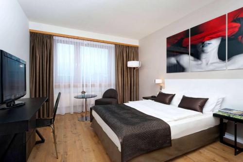 een hotelkamer met een bed en een flatscreen-tv bij Wyndham Stuttgart Airport Messe in Stuttgart