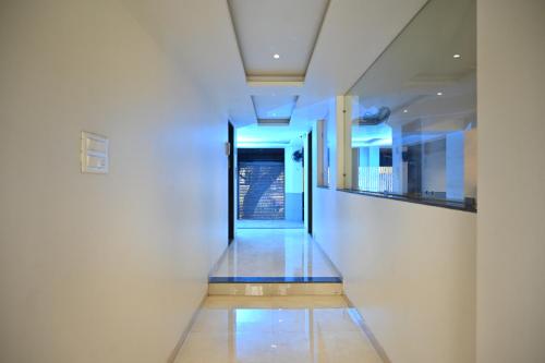 a hallway with white walls and blue lights at Majestic Hotel in Nashik