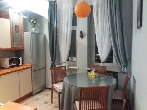 y cocina con mesa, sillas y nevera. en Apartment u Lidii in center of Kiev near railways station, en Kiev