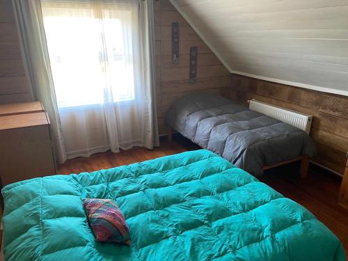 Un dormitorio con una cama grande y una ventana en Casa Apel Hostel, en Puerto Varas