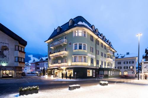 un grand bâtiment au milieu d'une rue dans l'établissement Post Hotel - Tradition & Lifestyle Adults Only, à San Candido