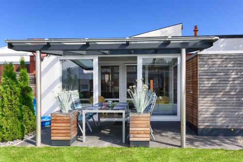 pergola ze stołem i krzesłami na patio w obiekcie Ferienhaus Inga w mieście Bensersiel