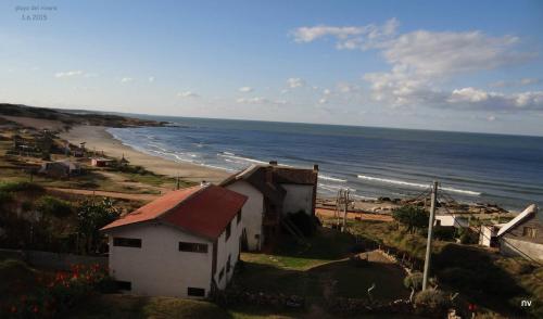 ein Haus auf einem Hügel neben einem Strand in der Unterkunft La Posada in Punta Del Diablo