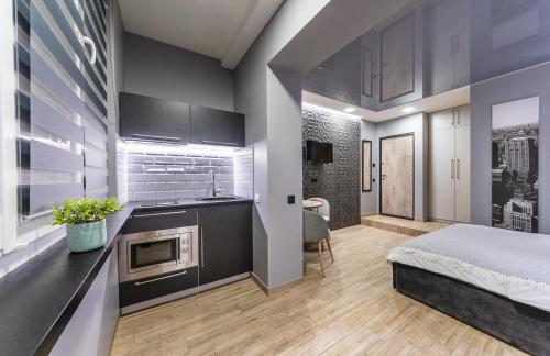 una camera con letto e una cucina con forno a microonde di Tomas apartments a Kiev