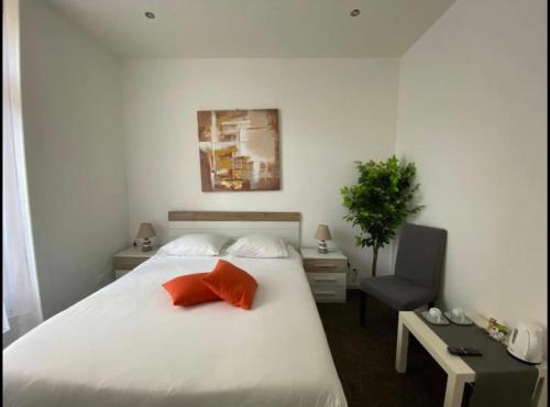 a bedroom with a white bed with a red pillow at B&B Guest House Du Lac in Montreux