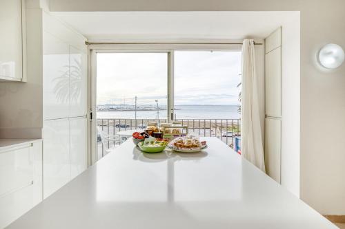 a white kitchen with a view of the ocean at Apartamento Roses Playa in Roses