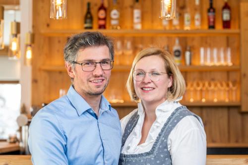 een man en een vrouw die voor een bar staan bij Hotel Haus Lungau in Mauterndorf