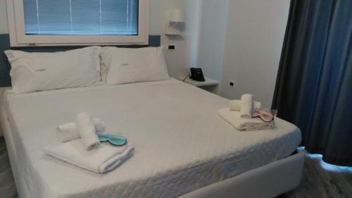 una camera da letto con un letto e asciugamani di Hotel Calypso a Pontecagnano