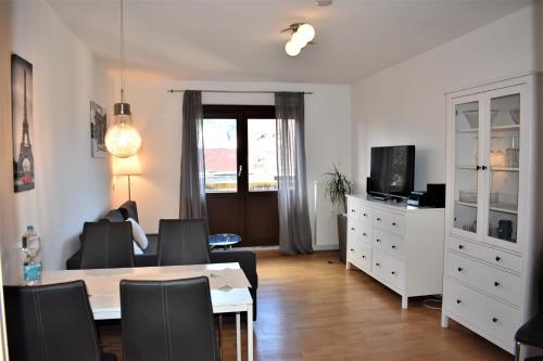 a living room with a table and chairs and a television at Altstadtblick in Heidelberg