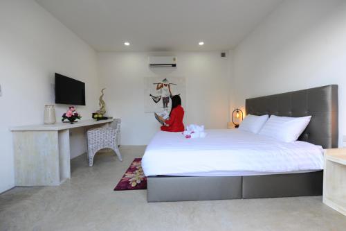 1 dormitorio con 1 cama grande y escritorio en Barong Resort, en Ban Phe