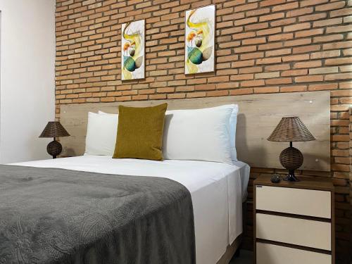 um quarto com uma cama e uma parede de tijolos em B & A Suites Inn Flats - Apart Flat Stratus em Anápolis