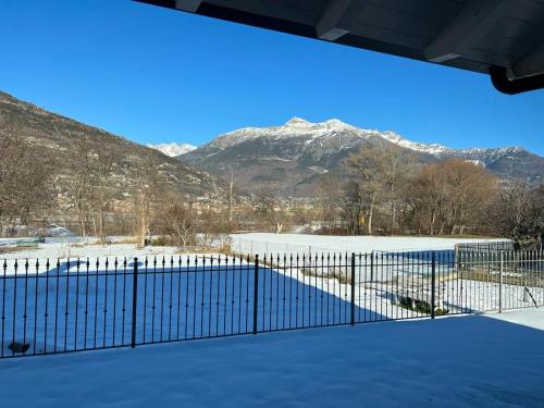 uma cerca com montanhas nevadas ao fundo em Villa Kate alloggio ad uso turistico VDA Gressan 0161 em Aosta