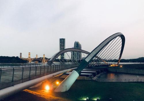 un puente sobre un río con edificios en el fondo en HillTree Homestay Putrajaya, en Putrajaya