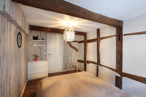 - une chambre avec un lit et un mur en bois dans l'établissement Le cosy 40 - maison typique au centre de Malmedy, à Malmedy