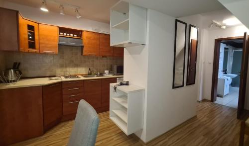 a kitchen with brown cabinets and a white refrigerator at Apartamenty Bajka Białka Tatrzanska z Kuchnią tel 60806 - 4835 in Białka Tatrzanska