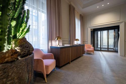 een lobby met stoelen en een bureau en een plant bij WorldHotel Casati 18 in Milaan