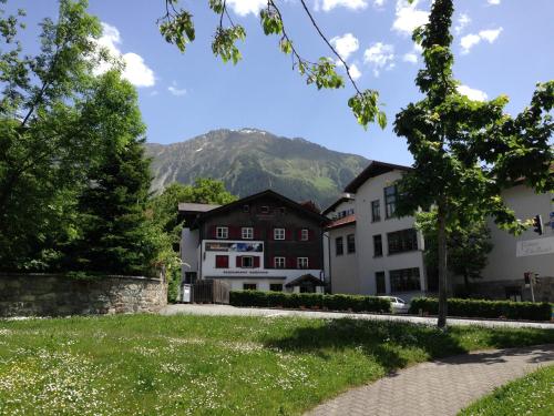 una casa con una montagna sullo sfondo di Adventure Hostel a Klosters