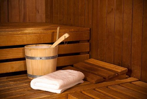 una sauna de madera con cubo y toalla en nestor Hotel Stuttgart-Ludwigsburg, en Ludwigsburg