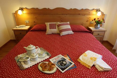 ein Bett mit einem Tablett mit Essen drauf in der Unterkunft Hotel Aiguille Noire in Courmayeur