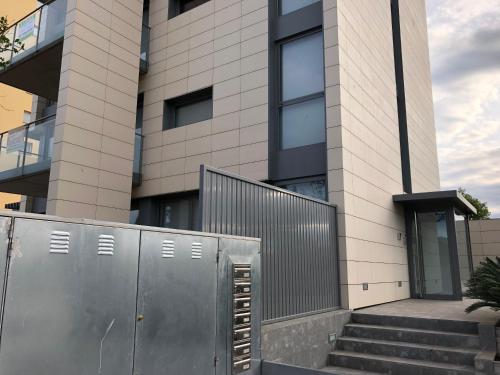 a building with a gate and stairs in front of it at Appartement plage Salata Rosas in Roses