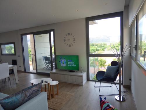 a living room with a couch and a tv and a table at Appartement plage Salata Rosas in Roses