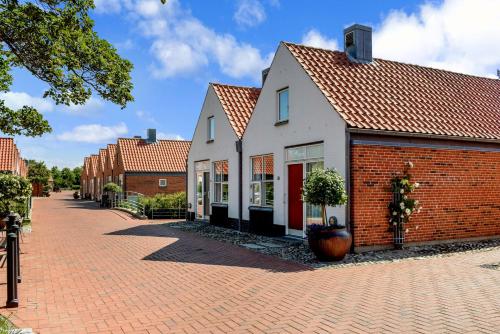 een wit en rood gebouw met een bakstenen stoep bij Ribe Byferie Resort in Ribe