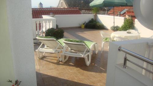 een patio met een tafel en stoelen en een parasol bij Apartments Vodice Marica in Vodice