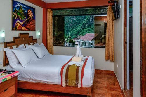 1 dormitorio con cama y ventana grande en Hostal Vista Waynapata 123, en Machu Picchu