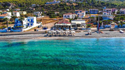 - une vue aérienne sur une plage avec des bâtiments bleus et l'eau dans l'établissement Laza Beach, à Skala