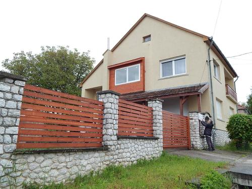 a woman standing in front of a fence at Bogácsa Apartman in Bogács