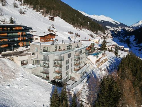 um edifício ao lado de uma montanha coberta de neve em Residenz Schooren des Alpes - Apartment SET - TOP 10 em Kappl