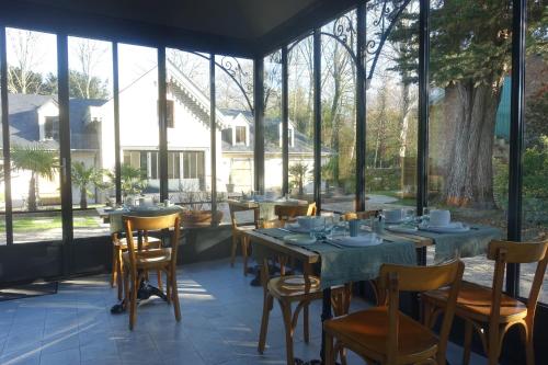 - une salle à manger avec des tables, des chaises et des fenêtres dans l'établissement Les Îles Vagabondes, à Saint-Malo