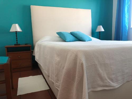 1 dormitorio con 1 cama con 2 almohadas azules en Camping Villa Park Zambujeira do Mar, en Zambujeira do Mar